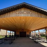 A wooden pavilion labeled Gazebo Park with picnic tables underneath, surrounded by grass and trees on a clear, sunny day. Beach, SD